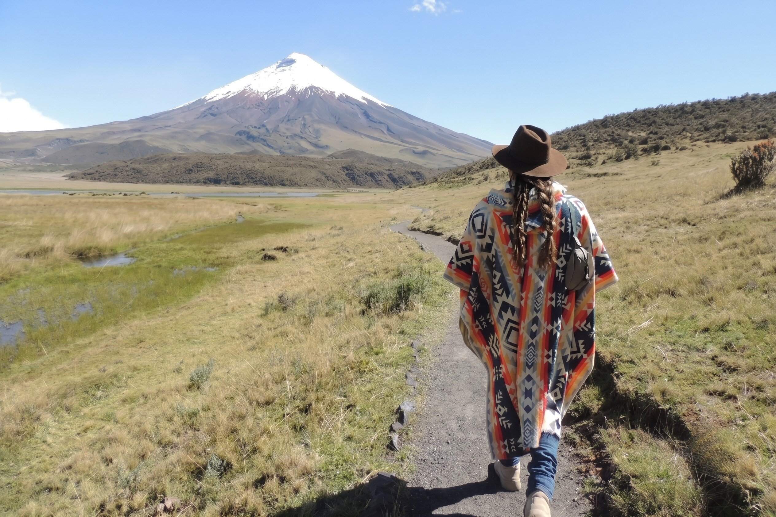 A tourist walking towards Cotopaxi Volcano in Ecuador