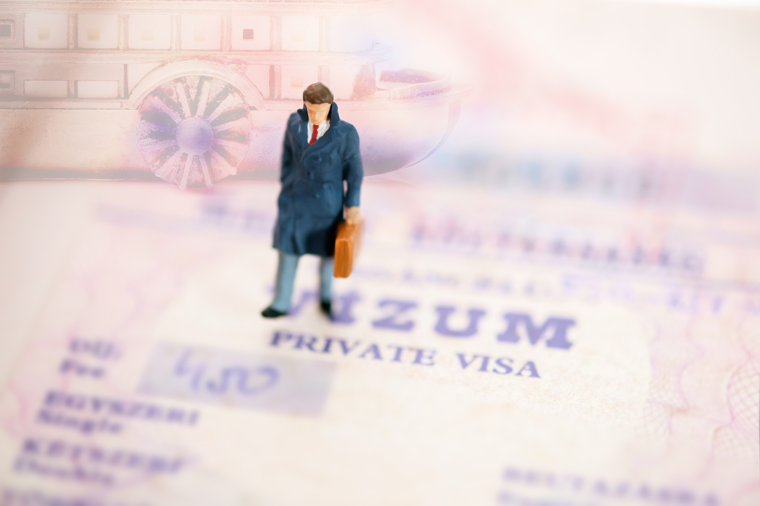 Miniature Businessman Walking On A Passport
